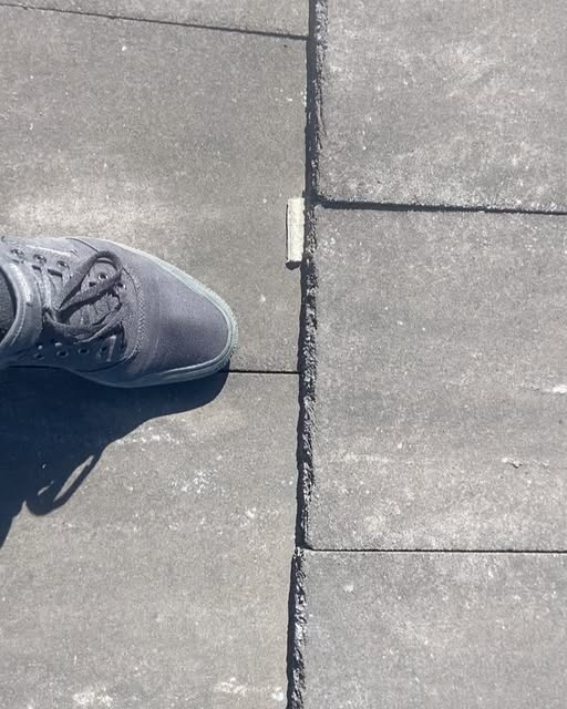 Roof tile inspection on a charcoal tiled roof