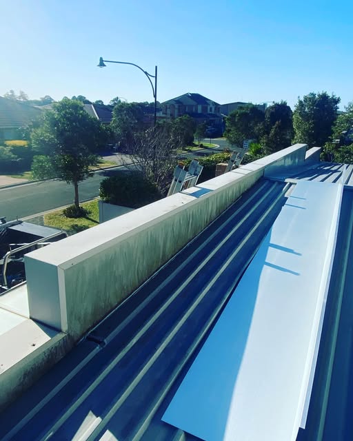 Corrugated metal roof, flashing and box gutter on a suburban job